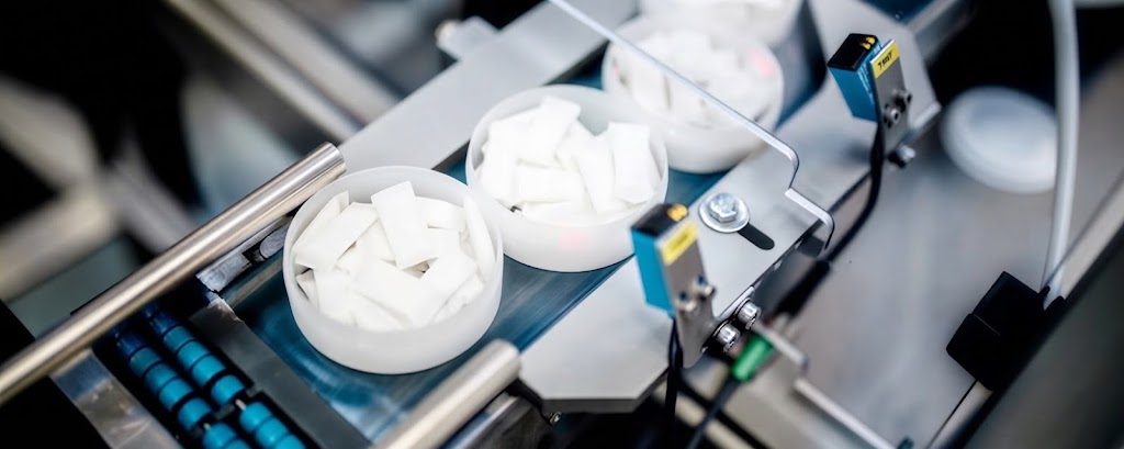 Nicotine pouches moving through the filling and inspection line